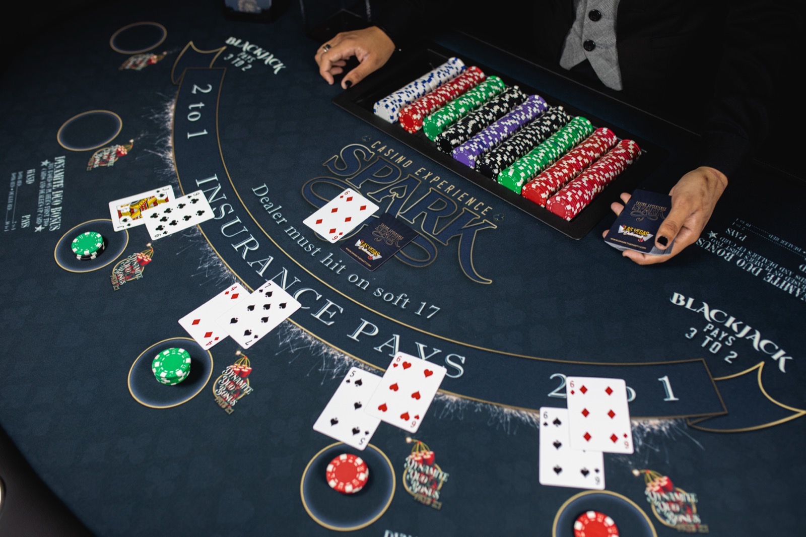 Spark dealer spreading cards on a custom Spark blackjack felt